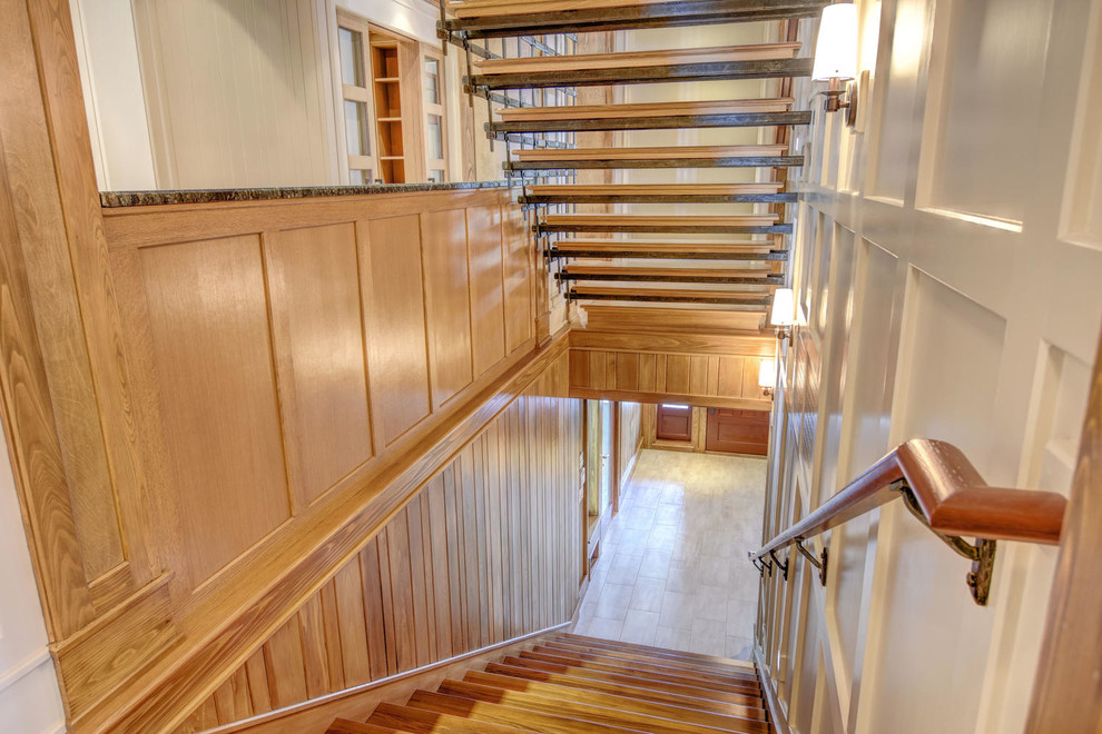 Idée de décoration pour un grand escalier sans contremarche flottant craftsman avec des marches en bois et un garde-corps en métal.