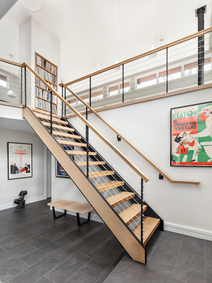 Cette photo montre un escalier sans contremarche droit tendance avec des marches en bois et un garde-corps en câble.