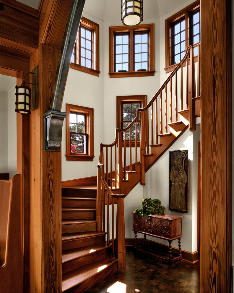 Aménagement d'un escalier courbe classique avec des marches en bois et des contremarches en bois.