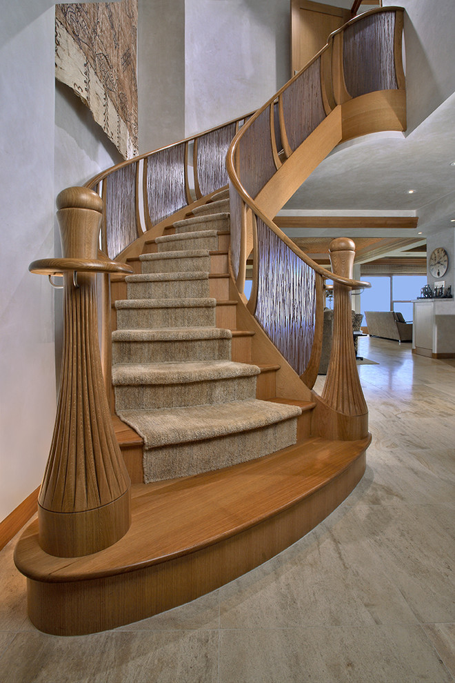 Large island style wooden curved staircase photo in Seattle with wooden risers