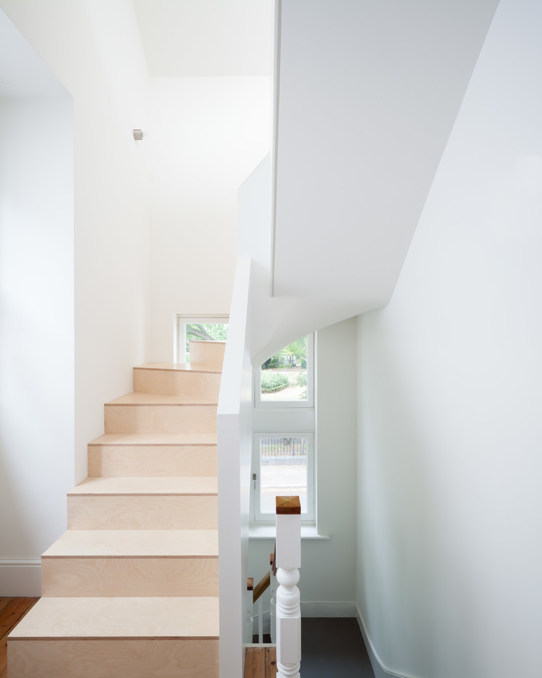 Imagen de escalera en U contemporánea pequeña con escalones de madera y contrahuellas de madera