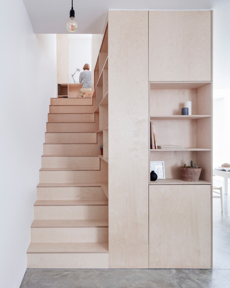 Photo of a modern wood straight staircase in London with wood risers.