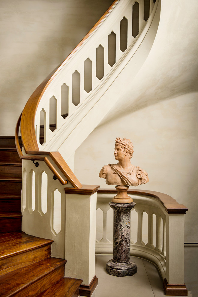 Пример оригинального дизайна: большая винтовая деревянная лестница в средиземноморском стиле с деревянными ступенями