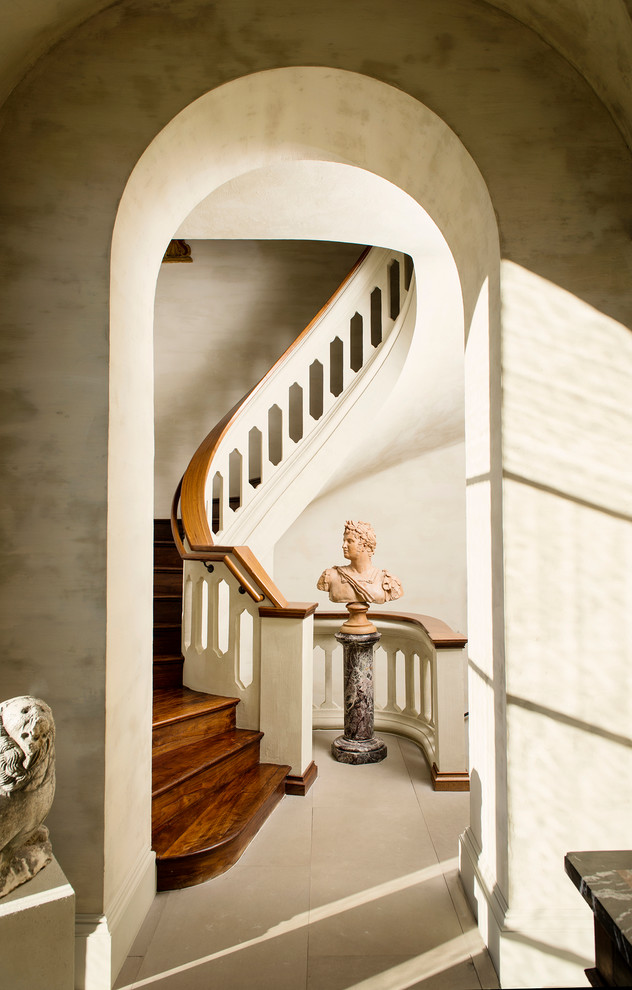 Imagen de escalera de caracol mediterránea grande con escalones de madera y contrahuellas de madera