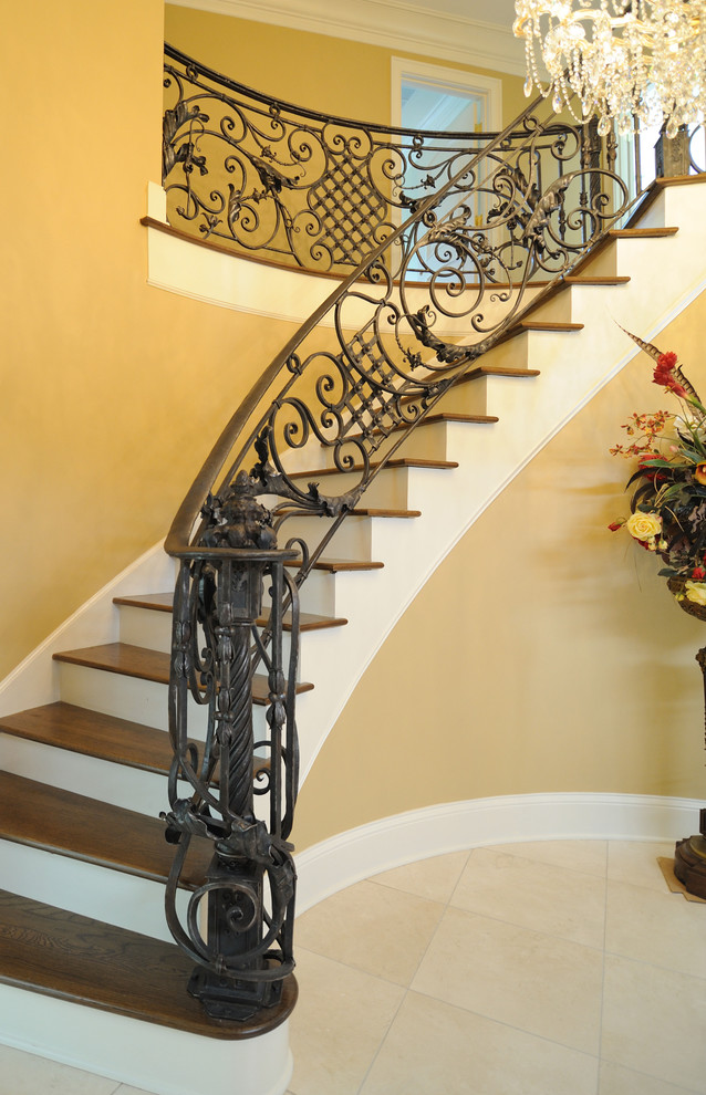 На фото: изогнутая лестница среднего размера в классическом стиле с деревянными ступенями и крашенными деревянными подступенками с