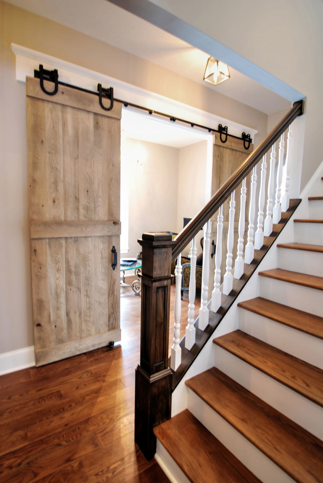 Example of a large classic wooden straight staircase design in Cleveland with painted risers