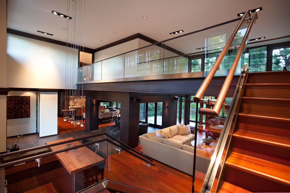 Photo of a large modern wood floating staircase in Other with wood risers.