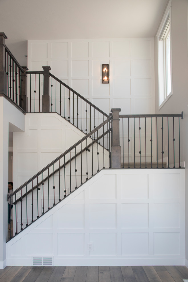Diseño de escalera en U de estilo americano grande con escalones enmoquetados, contrahuellas enmoquetadas y barandilla de madera
