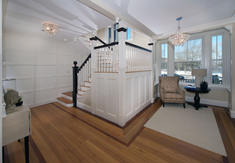 This is an example of a medium sized victorian wood u-shaped wood railing staircase in Boston with wood risers and feature lighting.