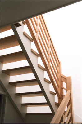 Ispirazione per una grande scala a "L" minimalista con pedata in legno e nessuna alzata