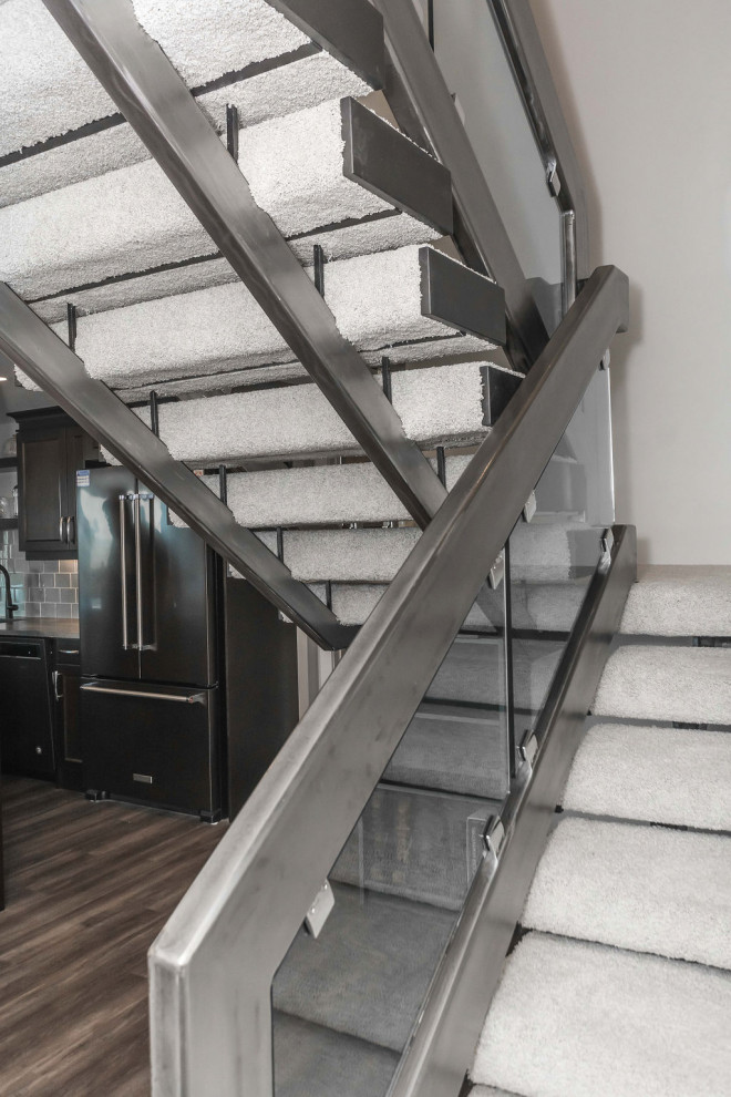 エドモントンにある高級な中くらいなエクレクティックスタイルのおしゃれな折り返し階段 (金属の手すり、カーペット張りの蹴込み板) の写真