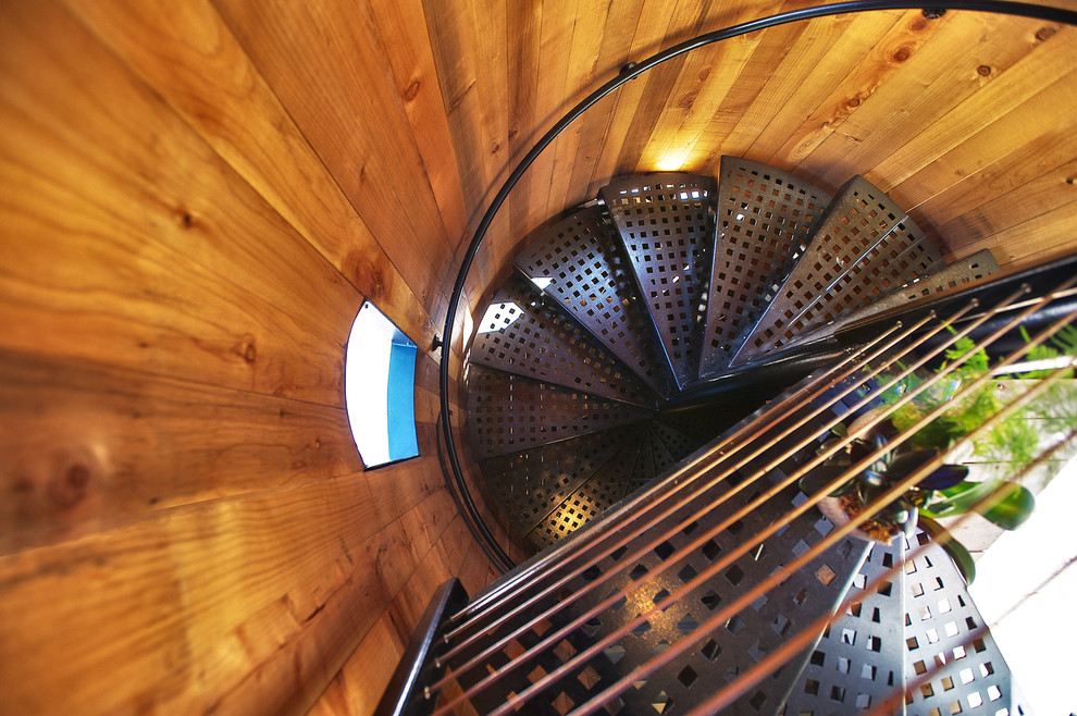 Пример оригинального дизайна: большая изогнутая лестница в стиле кантри с металлическими ступенями без подступенок