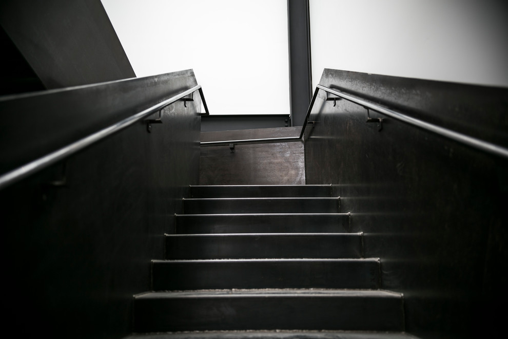 Large industrial metal u-shaped metal railing staircase in Seattle with metal risers.