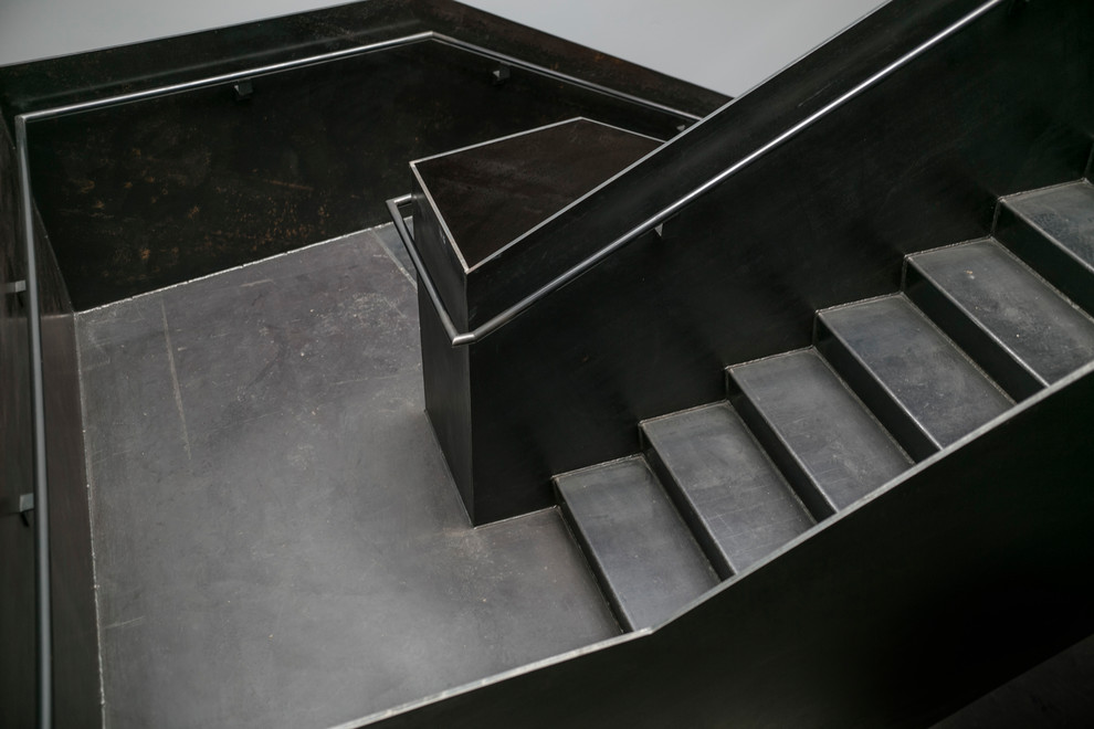 Imagen de escalera en U urbana grande con escalones de metal, contrahuellas de metal y barandilla de metal
