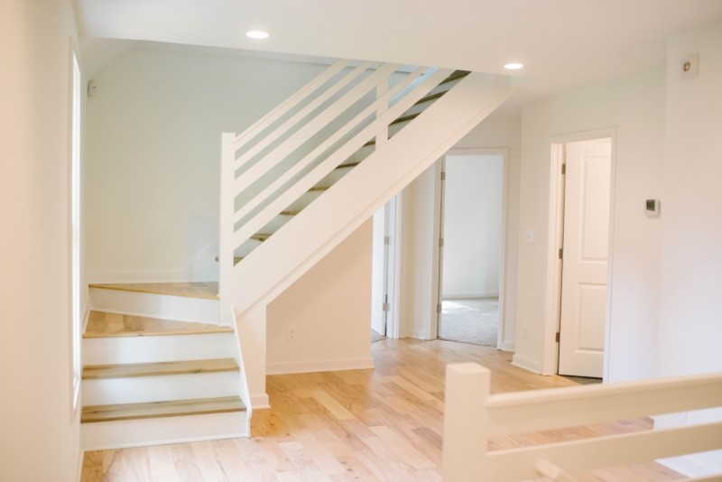 Idéer för mellanstora minimalistiska l-trappor i trä, med sättsteg i målat trä