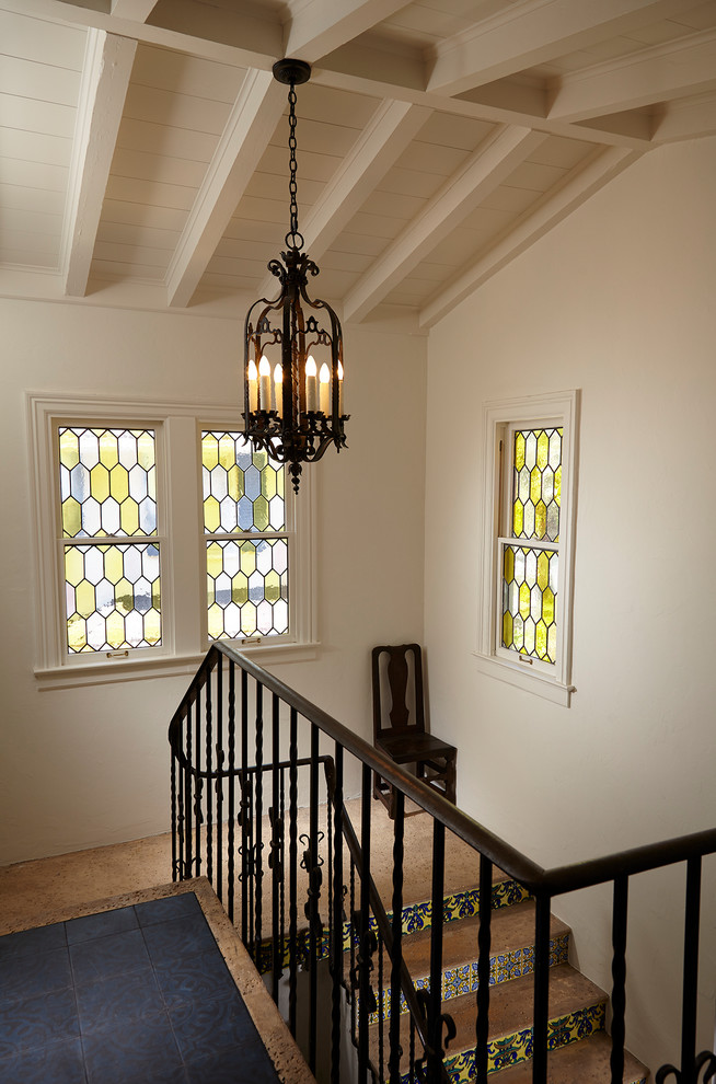 Example of a tuscan tile l-shaped metal railing staircase design in Miami with tile risers