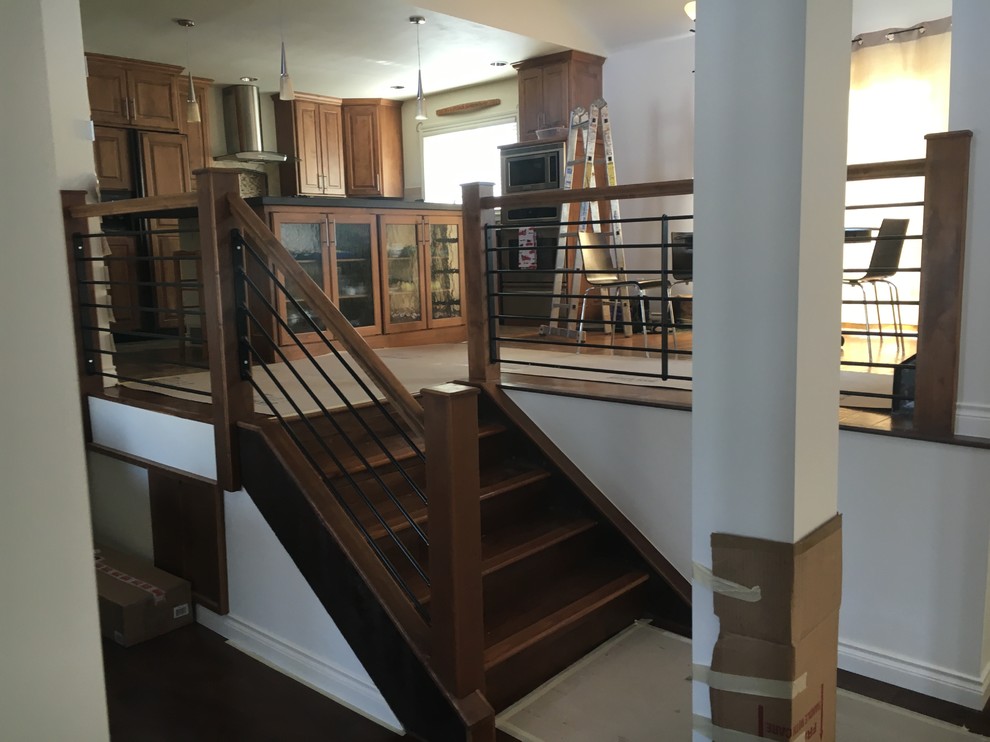 Imagen de escalera recta rústica de tamaño medio con escalones de madera, contrahuellas de madera y barandilla de madera