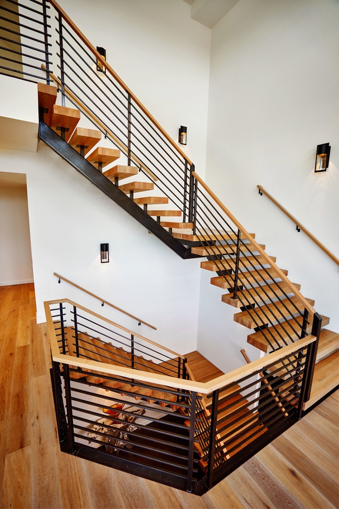 На фото: большая угловая лестница в стиле модернизм с деревянными ступенями без подступенок с