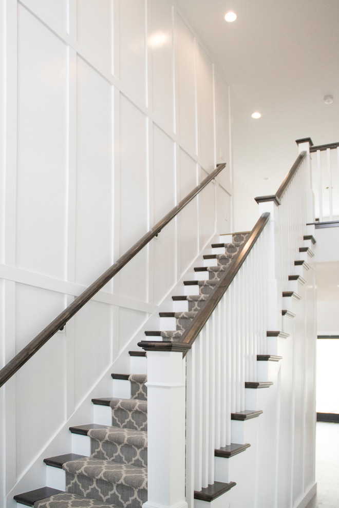 Example of a large country carpeted straight wood railing staircase design in Salt Lake City with carpeted risers