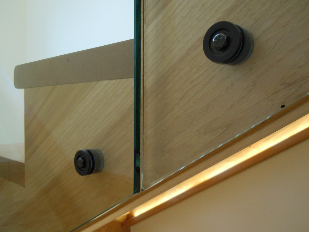 ボルチモアにある広いラスティックスタイルのおしゃれな折り返し階段 (ガラスの蹴込み板、木材の手すり) の写真