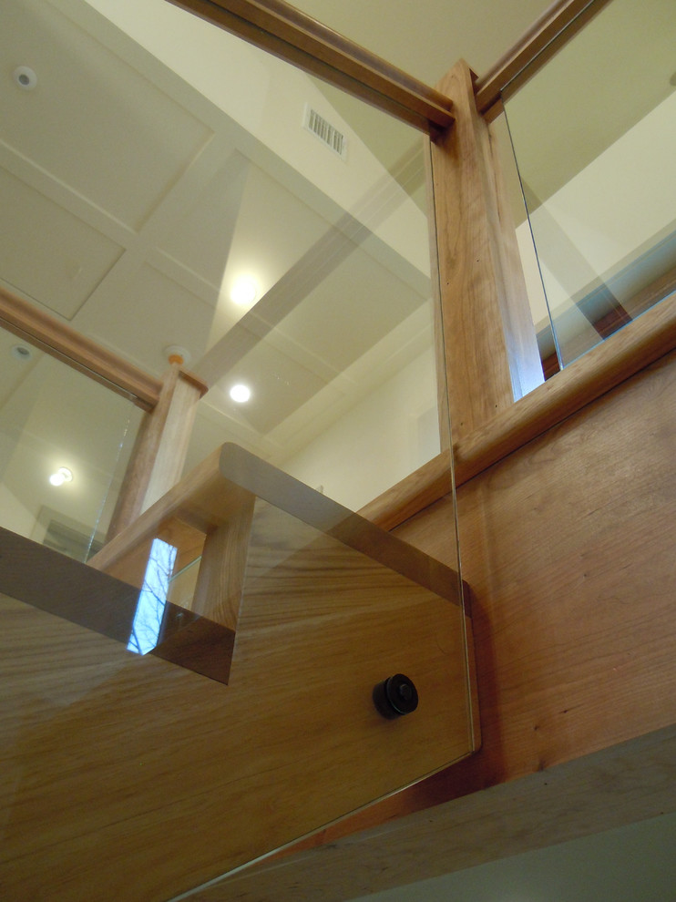 На фото: большая п-образная лестница в стиле рустика с крашенными деревянными ступенями, стеклянными подступенками и деревянными перилами