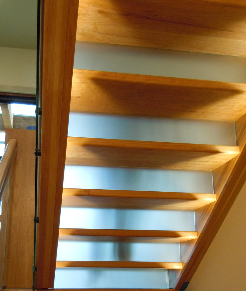 Imagen de escalera en U rústica grande con escalones de madera pintada, contrahuellas de vidrio y barandilla de madera
