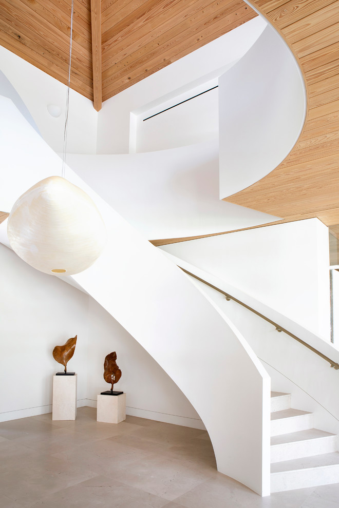 Источник вдохновения для домашнего уюта: большая изогнутая лестница в современном стиле с ступенями из известняка и подступенками из известняка