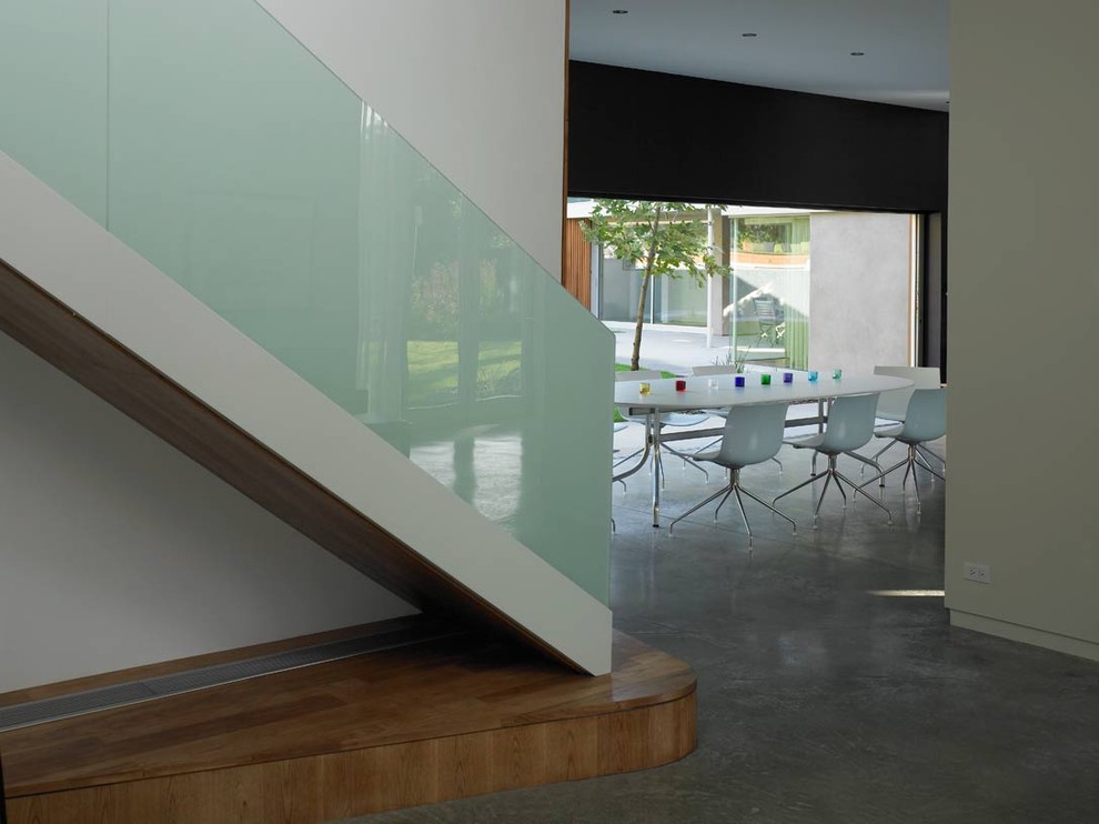 Свежая идея для дизайна: лестница в стиле модернизм с стеклянными перилами - отличное фото интерьера