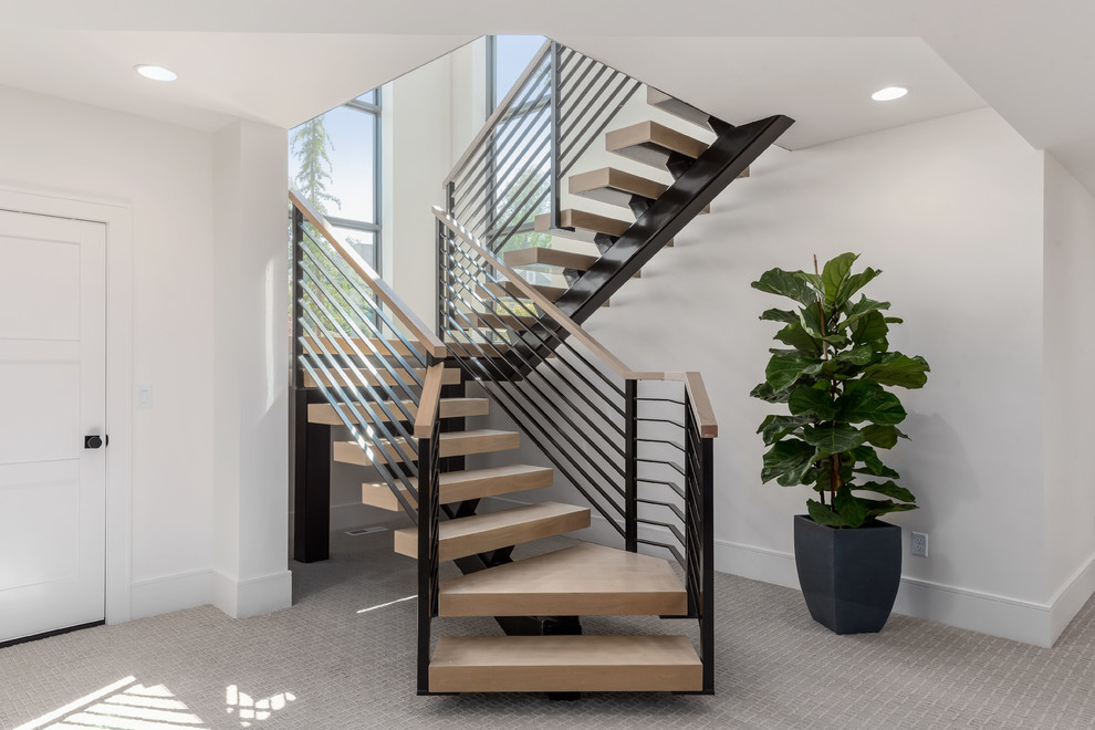 Idée de décoration pour un grand escalier design en U avec des marches en bois, des contremarches en métal et un garde-corps en matériaux mixtes.