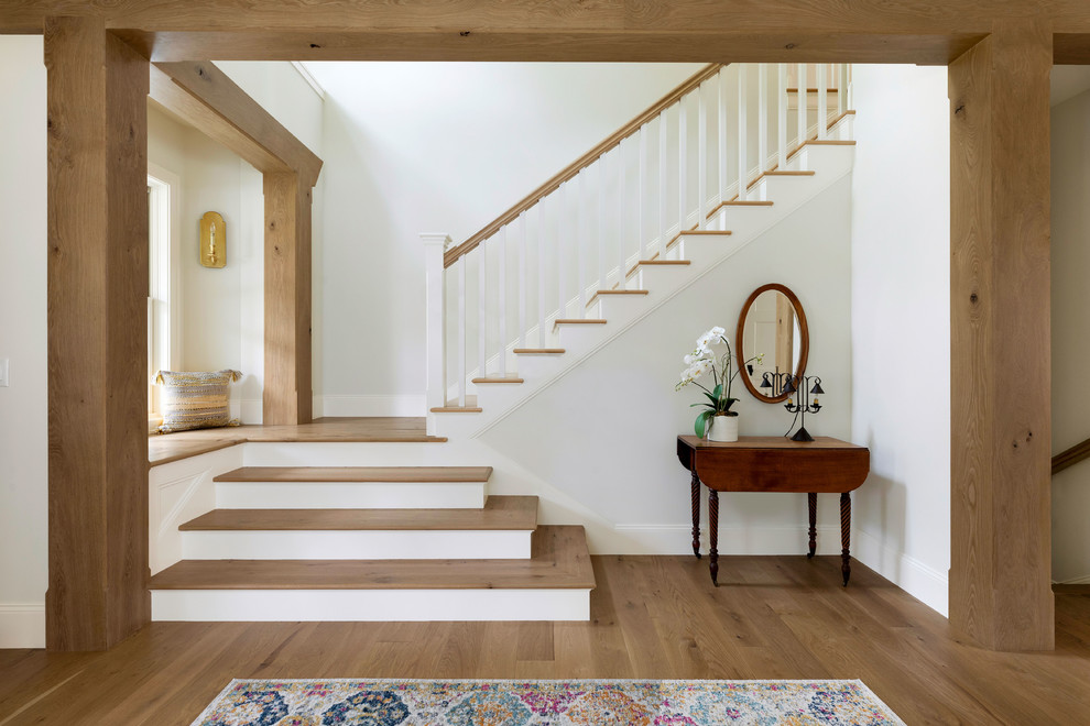 Modelo de escalera en L de estilo de casa de campo con escalones de madera, contrahuellas de madera pintada y barandilla de madera