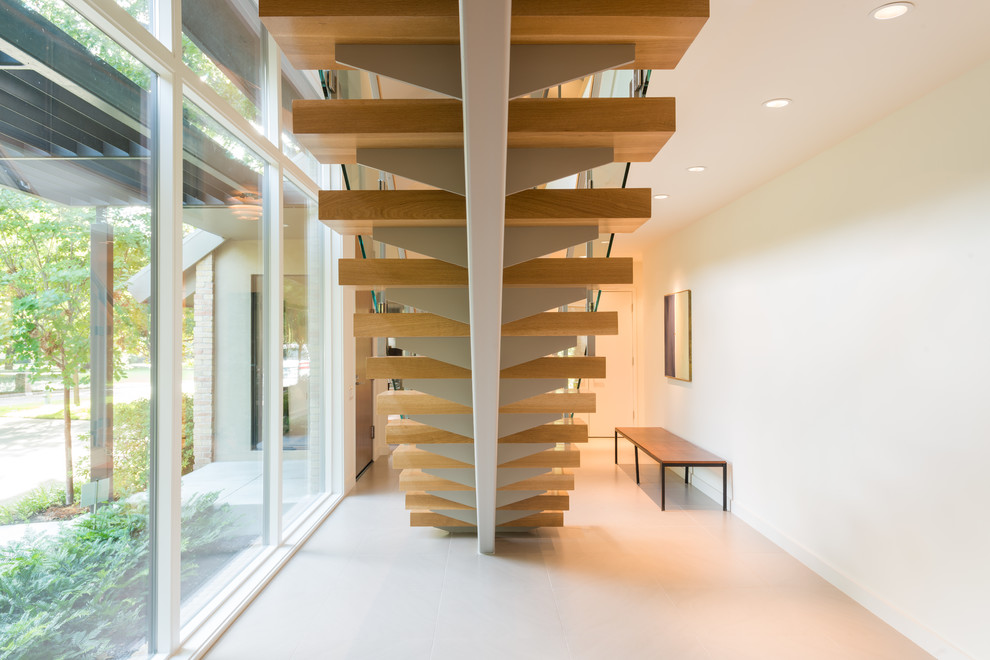 Imagen de escalera suspendida contemporánea grande con escalones de madera y contrahuellas de metal