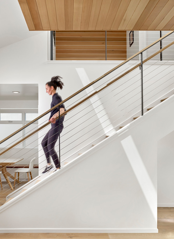 Imagen de escalera recta minimalista con escalones de madera, contrahuellas de madera y barandilla de varios materiales