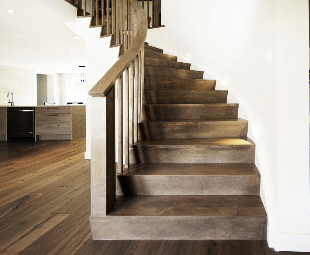 Ejemplo de escalera curva moderna con escalones de madera y contrahuellas de madera