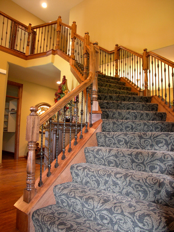 Exempel på en mellanstor klassisk svängd trappa, med heltäckningsmatta och sättsteg med heltäckningsmatta