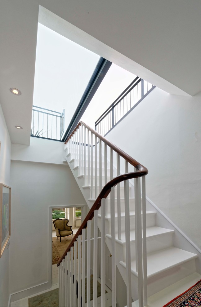 Example of a mid-sized classic painted straight wood railing staircase design in London with painted risers