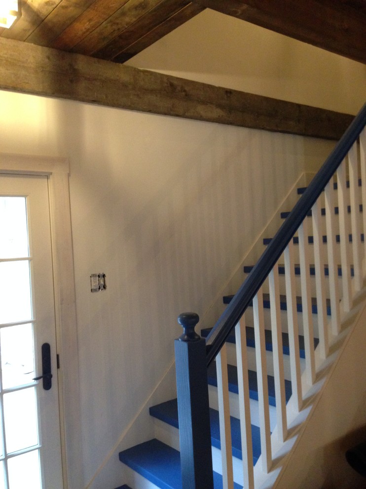 Modelo de escalera en L rústica con escalones de madera pintada y contrahuellas de madera pintada