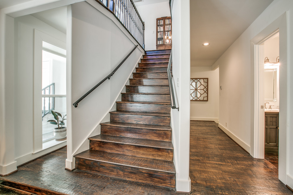 This is an example of a medium sized farmhouse wood spiral metal railing staircase in Dallas with wood risers.