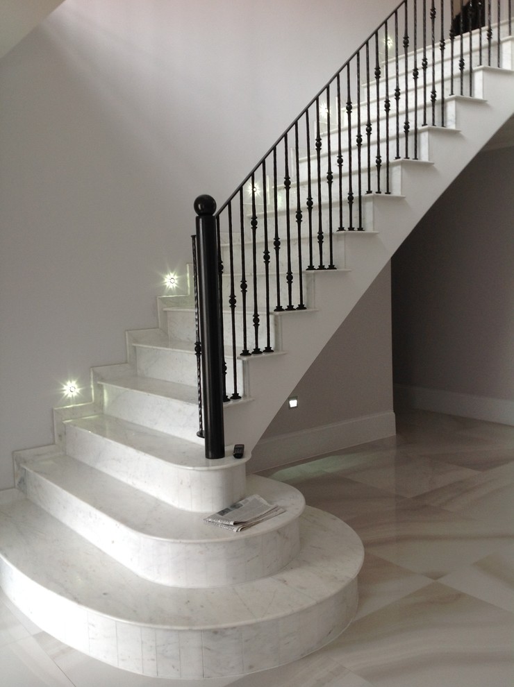 Inspiration for a contemporary straight metal railing staircase in Other with marble treads and marble risers.