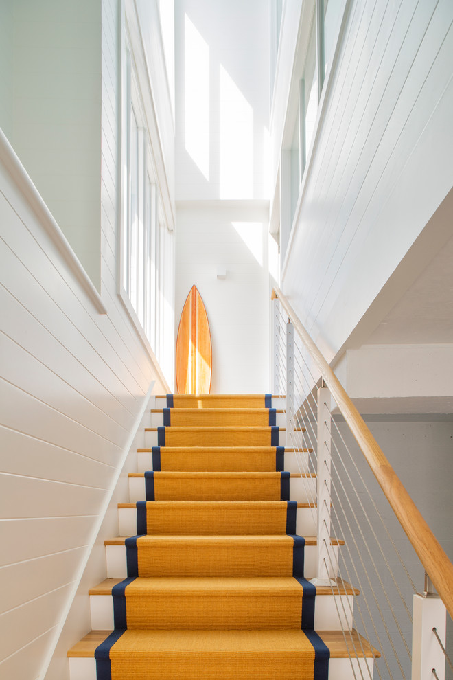 Idée de décoration pour un grand escalier droit marin avec des marches en bois, des contremarches en bois et un garde-corps en bois.