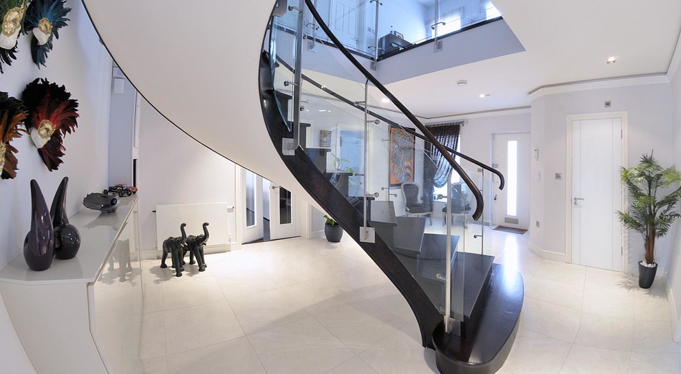 Inspiration pour un escalier peint courbe design de taille moyenne avec des marches en bois peint, un garde-corps en verre et éclairage.