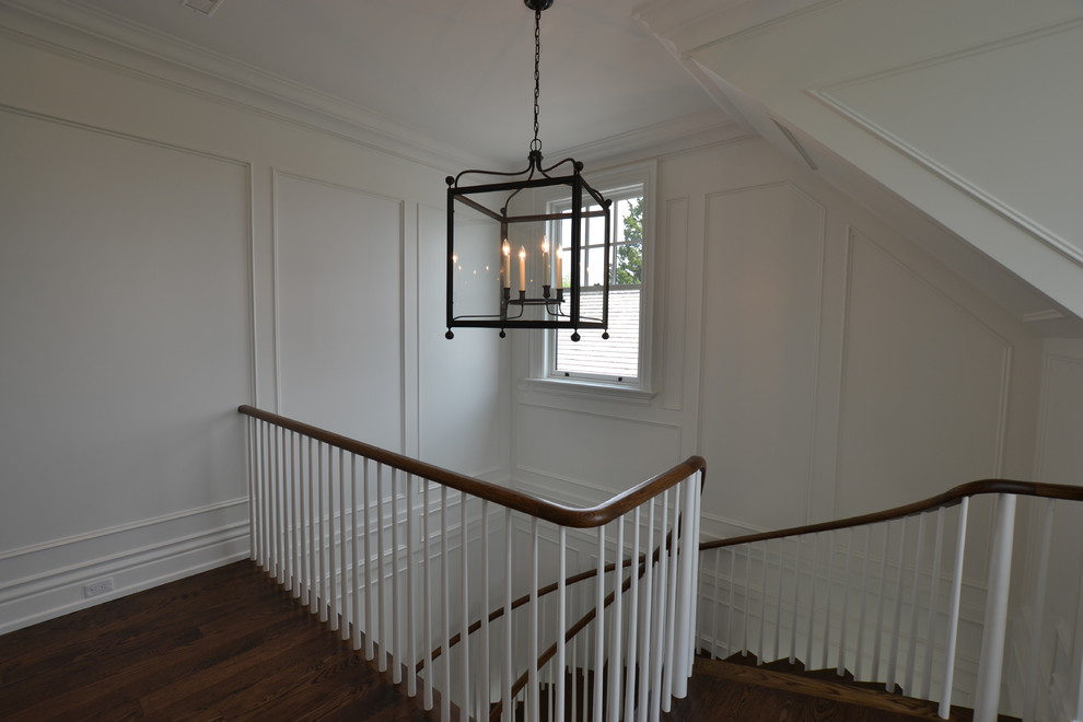 Пример оригинального дизайна: угловая лестница в классическом стиле с деревянными ступенями, крашенными деревянными подступенками и деревянными перилами