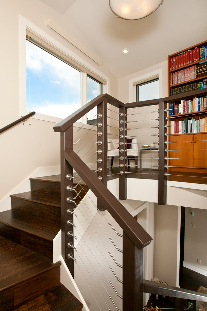 This is an example of a contemporary wood l-shaped wire cable railing staircase in Other with wood risers.