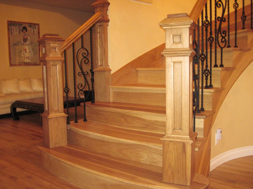 На фото: изогнутая деревянная лестница среднего размера в классическом стиле с деревянными ступенями