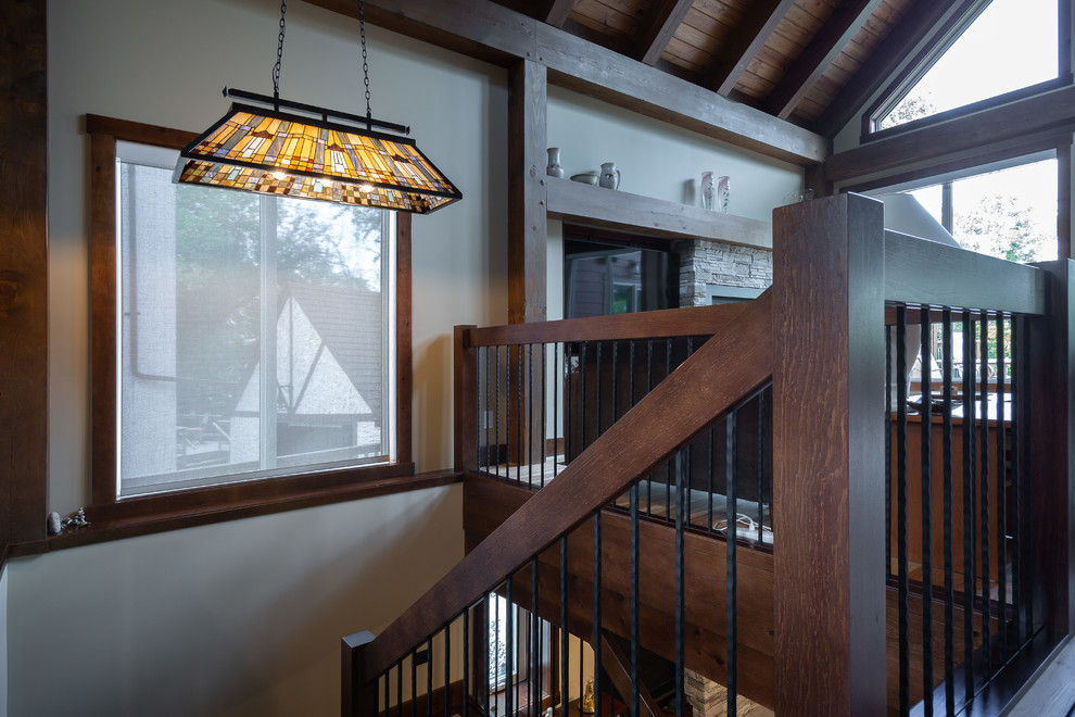 Cette image montre un grand escalier craftsman en U avec des marches en bois, des contremarches en bois et un garde-corps en matériaux mixtes.
