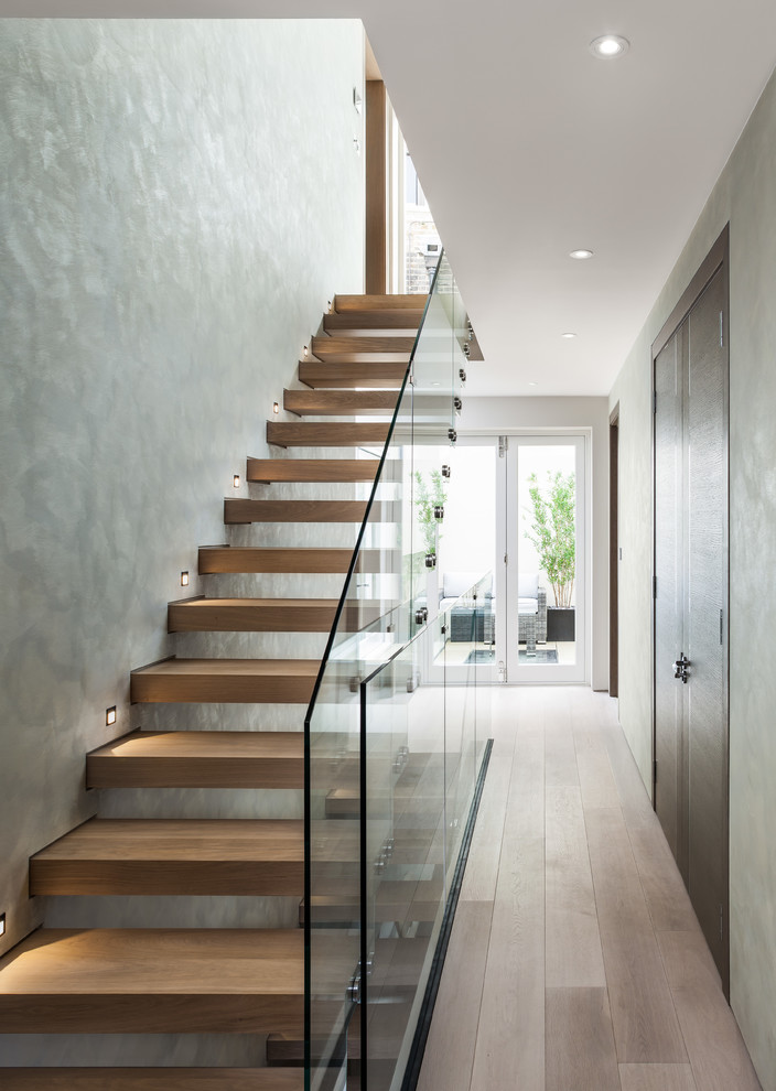 Foto de escalera recta contemporánea sin contrahuella con escalones de madera y barandilla de vidrio
