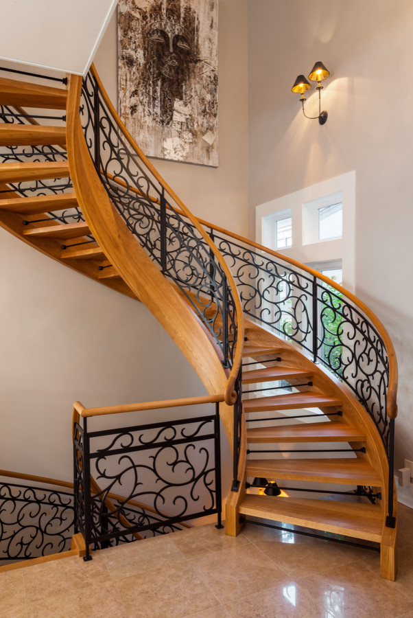 Large contemporary wood curved staircase in Seattle with open risers.