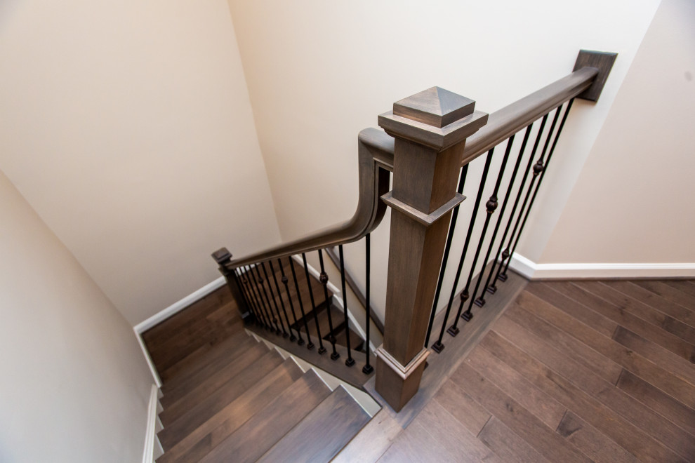 Large traditional wood u-shaped metal railing staircase in DC Metro with wood risers.