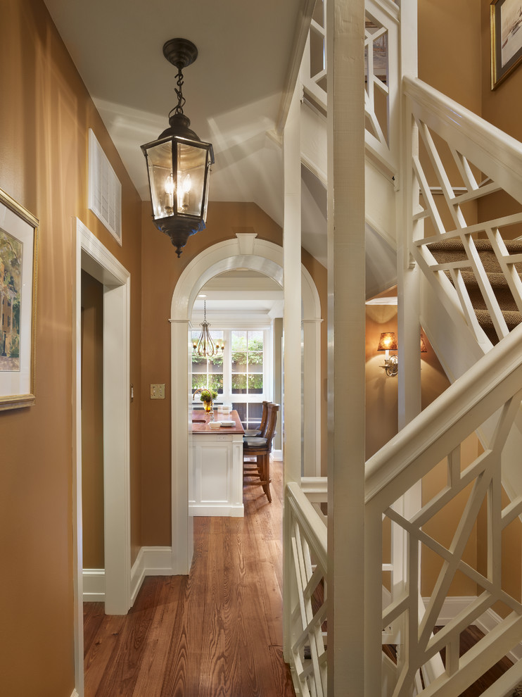 На фото: лестница в классическом стиле с ступенями с ковровым покрытием, ковровыми подступенками и деревянными перилами