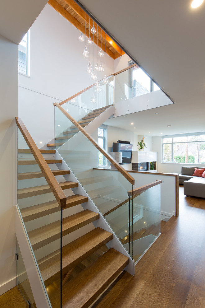 Idée de décoration pour un grand escalier design en L avec des marches en bois.