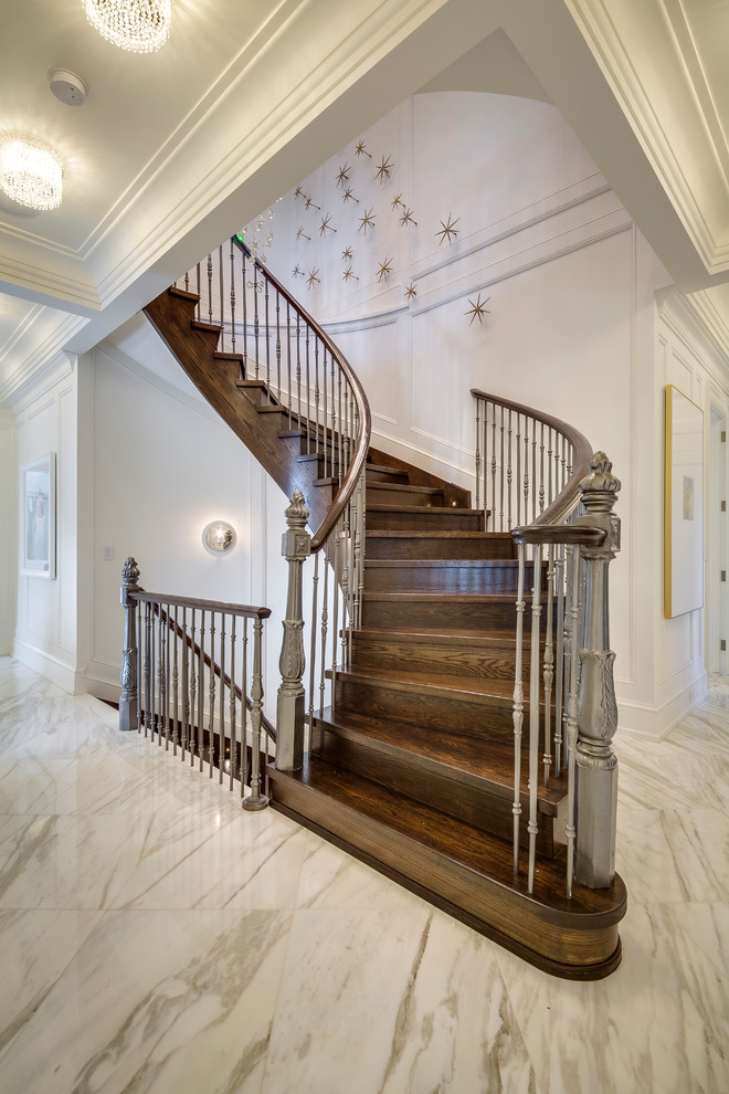 Идея дизайна: большая изогнутая деревянная лестница в классическом стиле с деревянными ступенями